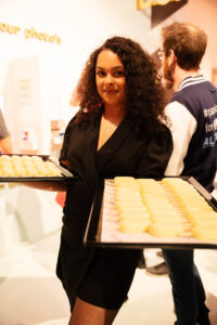 Vrouw in zwarte outfit houdt twee dienbladen met SWP-199-producten vast op een evenement.