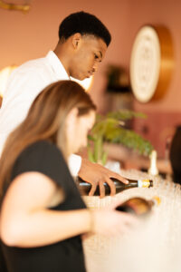 Twee personen schenken champagne in glazen tijdens een evenement.