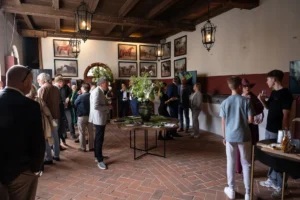 Bezoekers verzamelen zich in een sfeervolle ruimte met bloemen en kunst aan de muur tijdens The Perridon Collection op Landgoed Mariënwaerdt.