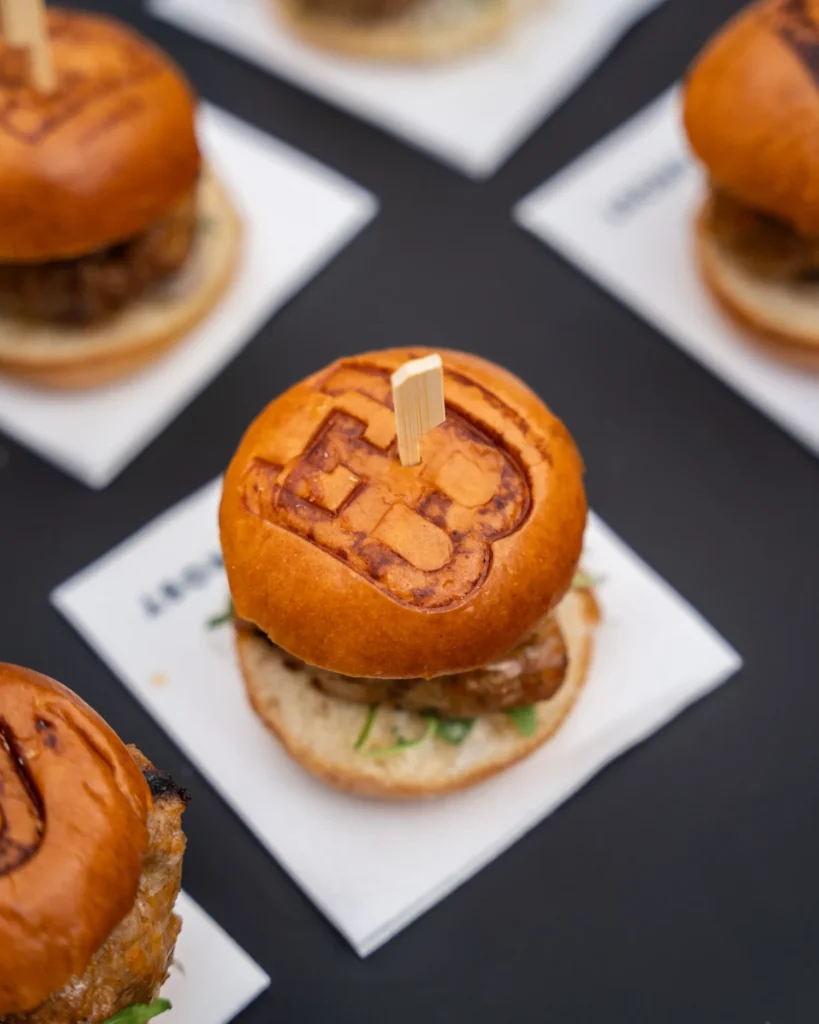 Mini-hamburgers met het Bugatti-logo op het broodje, geserveerd op servetten tijdens Wheels Marienwaerdt.