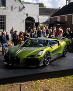 Groene Bugatti hypercar tentoongesteld op een verhoogd platform tijdens The Perridon Collection op Landgoed Mariënwaerdt, omringd door toeschouwers.