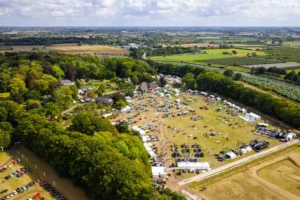 Luchtfoto van het klassieke auto-evenement Wheels at Marienwaerdt van The Perridon Collection, gelegen op een groot landgoed omringd door groene velden en bossen.