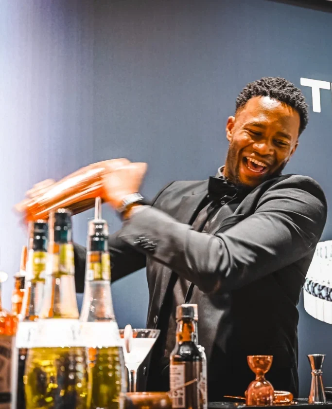 Professionele bartender van Served With Passion bereidt een cocktail tijdens een high-end event. De foto straalt energie, vakmanschap en passie uit – kenmerkend voor de cocktailshakers van Served With Passion die topkwaliteit, sfeer en beleving brengen op ieder evenement.