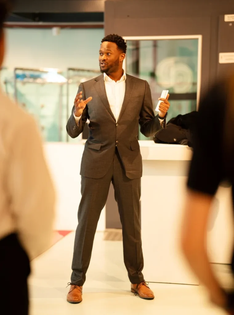 Man in pak geeft een presentatie tijdens een bijeenkomst op kantoor.