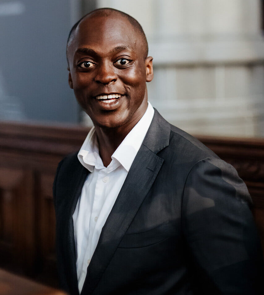 Japheth Bediako, medeoprichter en hospitality professional bij Served With Passion B.V., in een elegant interieur. Gekleed in donker pak en witte blouse straalt hij gastvrijheid, professionaliteit en leiderschap uit — eigenschappen die de hoogwaardige hospitality-diensten van Served With Passion typeren.