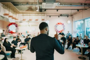 Man geeft inspirerende presentatie aan groep jongeren tijdens een bijeenkomst over ontwikkelkansen.